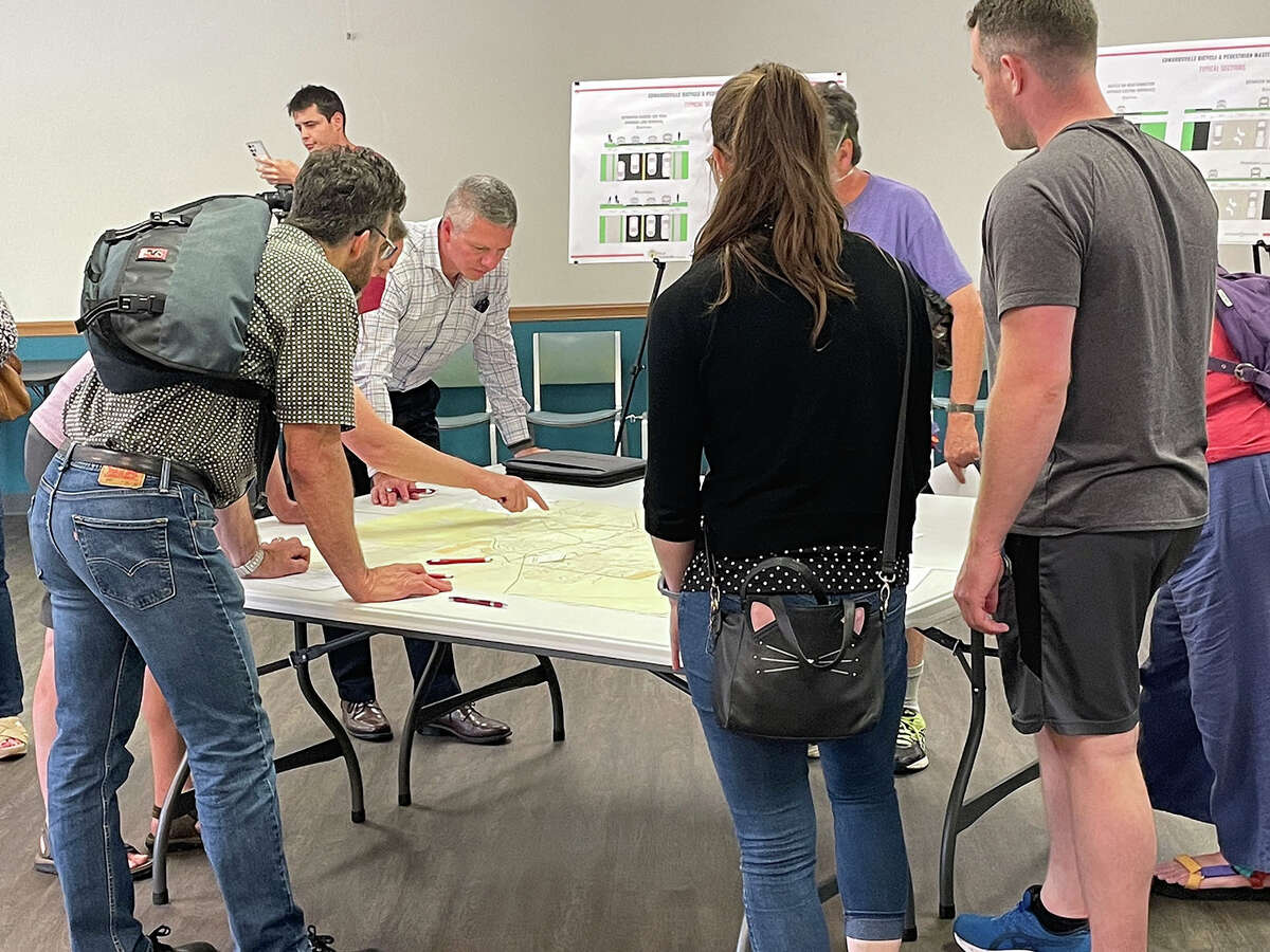 Alderman SJ Morrison, background, points to the map of Edwardsville while fielding residents' questions at Main Street Community Center Thursday about which streets should be prioritized as bicycle and pedestrian corridors. 