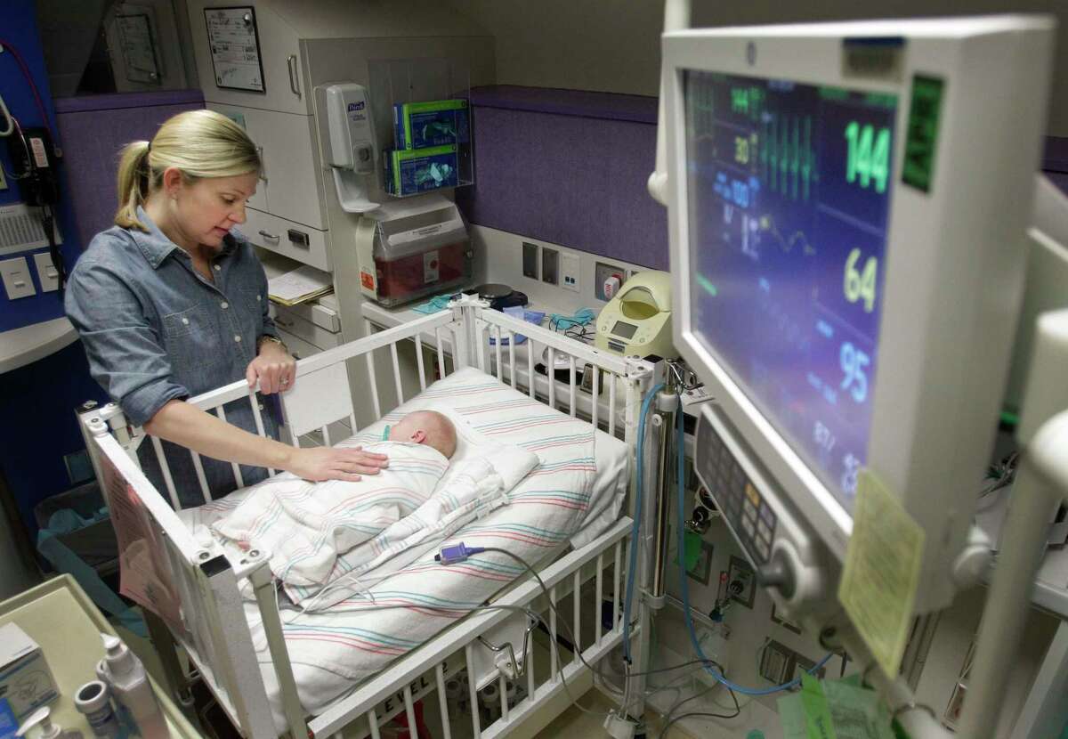 Angie Light, of Houston poses with her 3-week-old daughter, Georgina Adaline Light, in the neonatal intensive care unit at Texas Children’s Hospital on Jan. 8, 2014, in Houston. The newborn is recovering from respiratory syncytial virus, or RSV, a respiratory virus that infects the lungs and breathing passages. While it can affect adults, it’s mostly seen in pediatric patients. The virus has similar symptoms to the flu.