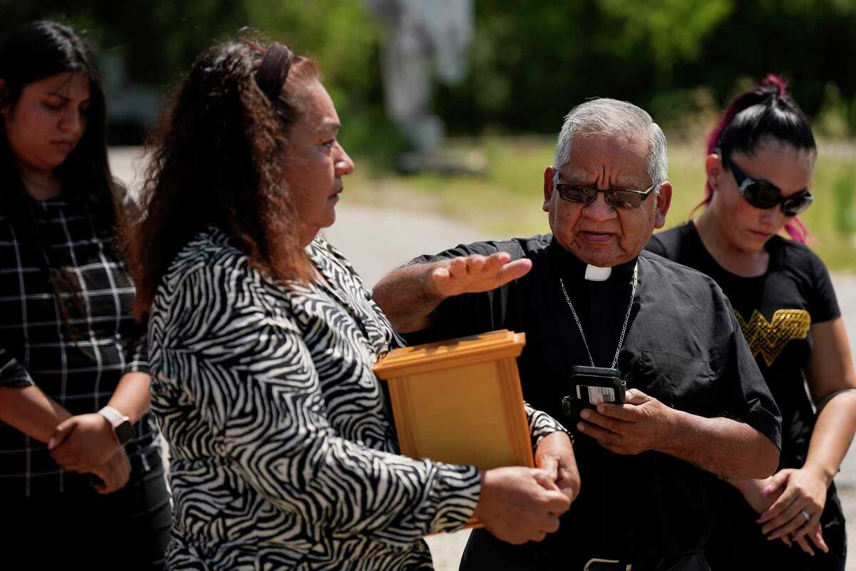 Retired priest of the Episcopal Church, Alejandro Montes, blesses the ashes of Sajid Barajas, Friday, June 10, 2022, in Houston at East End where he was killed while he was riding his bicycle from work toward his home at night. Sajid Barajas’ mother Policronia Islas holds a box with his ashes during a press conference on which information about his death was shared with the public in hopes that someone can give information about the incident.