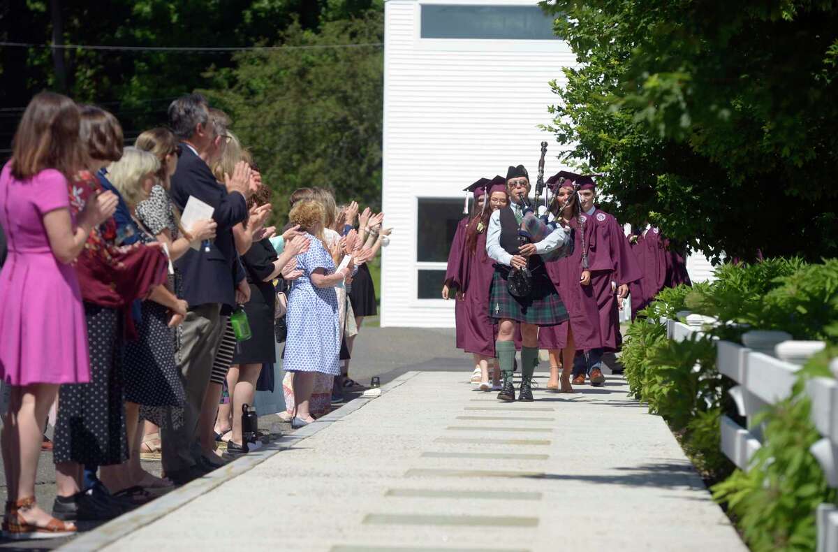 A piper leads the class of 2022 through a line of faculty and staff to the Commencement of Wooster School, Friday morning, June 10, 2022, Danbury, Conn.