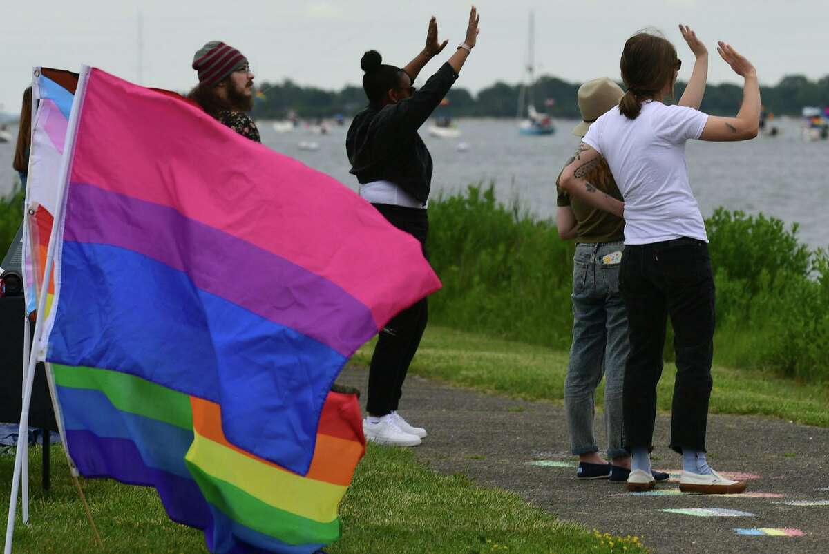 Participants at the viewing party at Veteran's Park watch as the Pride Parade of Sail motors through Norwalk Harbor Saturday, June 12, 2021, in Norwalk, Conn.