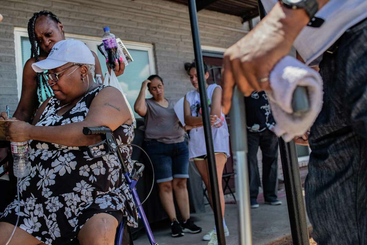 Rose Plaza Apartments resident Pamela Davis, 57, adds her name to a list as she and other residents gather to talk about issues at the Rose Plaza Apartments, Friday, June 10, 2022, in Houston.