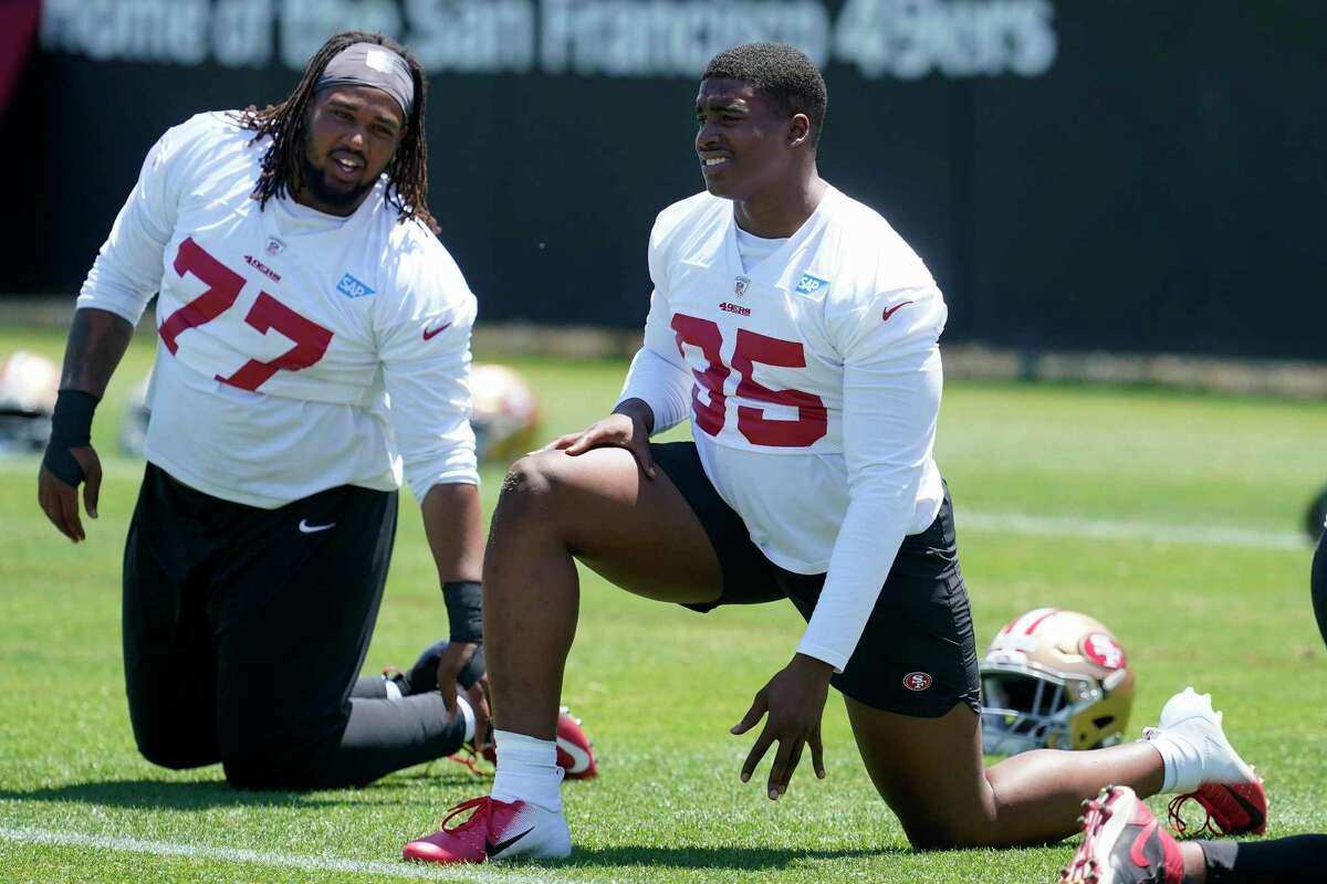 San Francisco 49ers defensive linemen Kevin Atkins (77) and Drake Jackson (95) stretch before taking part in drills at the NFL football team's practice facility in Santa Clara, Calif., Tuesday, May 24, 2022. (AP Photo/Jeff Chiu)