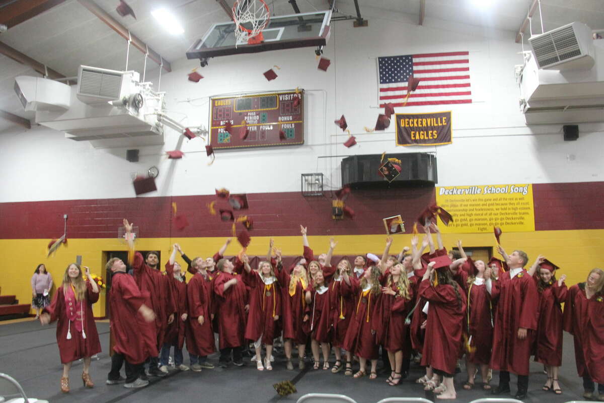 The graduates toss their caps into the air to celebrate their accomplishments.