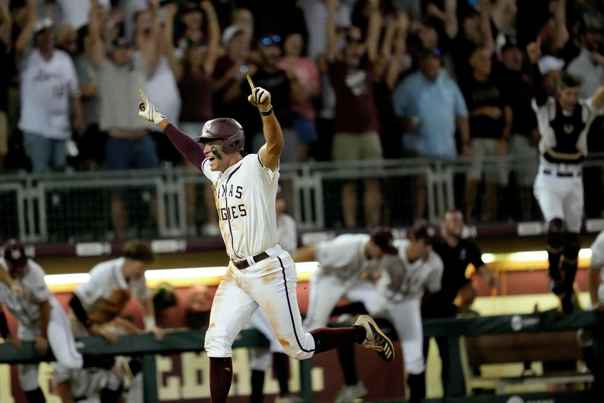 Fan and players celebrate as Texas A&M's Trevor Werner scores the winning run against Louisville during an NCAA college baseball super regional tournament game early Saturday, June 11, 2022, in College Station, Texas. (AP Photo/Sam Craft)