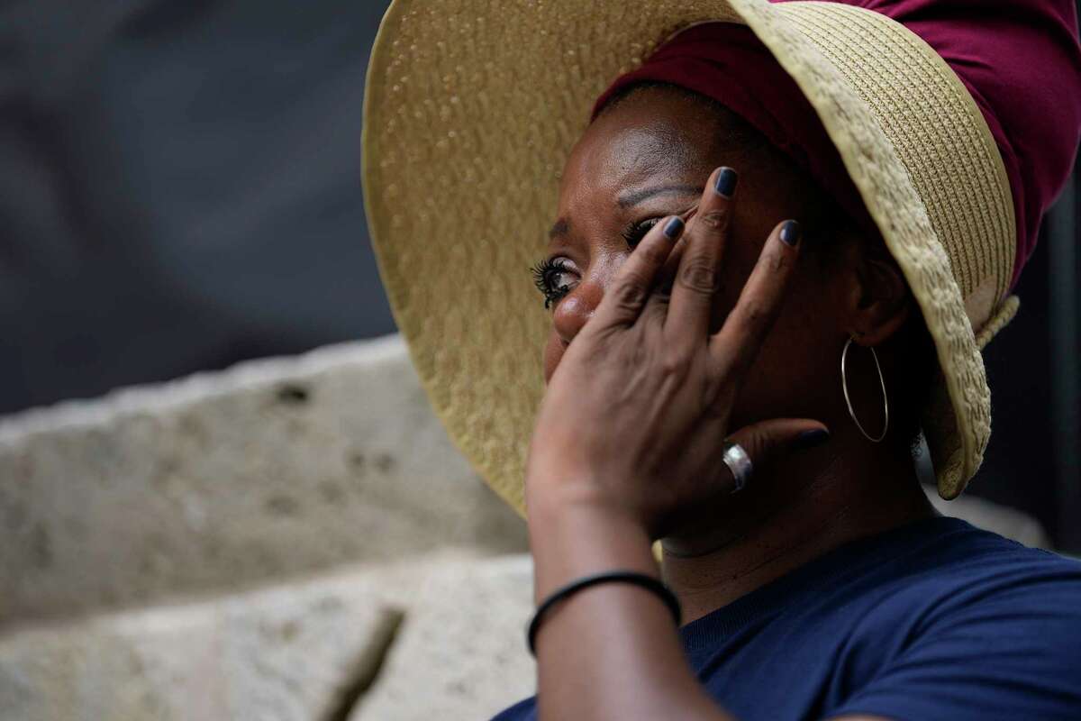 A person dries her tears as she gets emotional listening to a poem about what is like to be a student during an era of prevalent school shooting, Saturday, June 11, 2022, in Houston. Hundreds gathered at Houston City Hall to attend the student-led March For Our Lives rally.