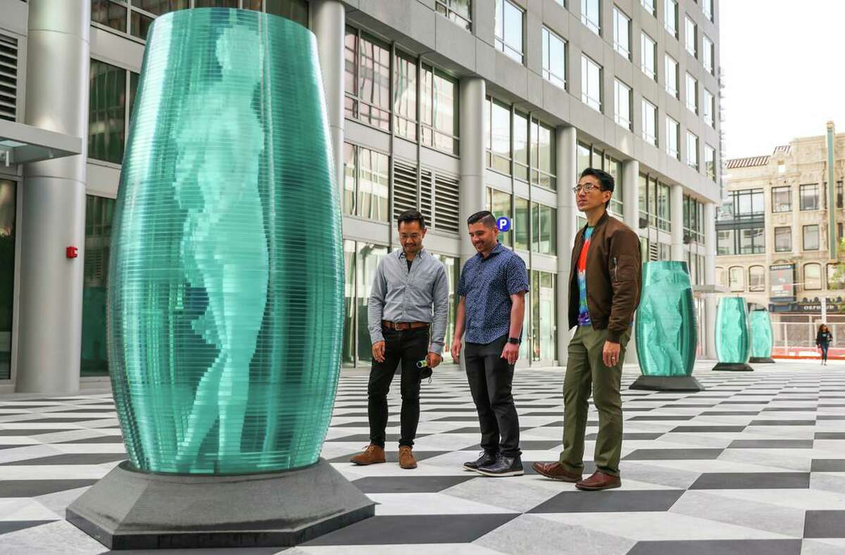 Mark Guevarra (left), Daniel Morgan and Conway Gregory check out a sculpture at the Triinity Place plaza in San Francisco.