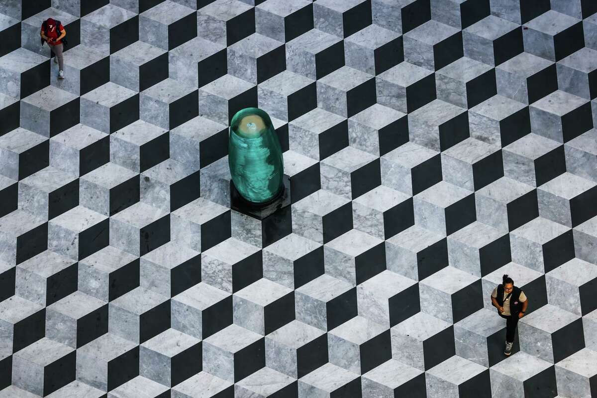 The herringbone pattern of the white and black marble flooring is seen from above at Trinity Place in San Francisco.