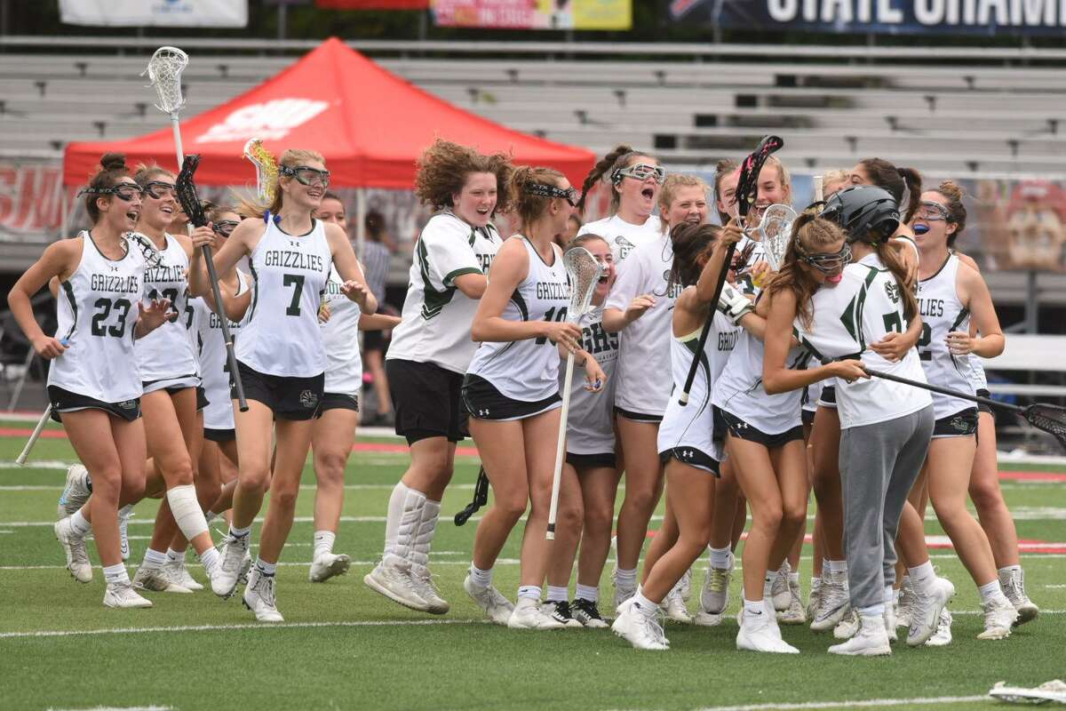 Members of the Guilford girls lacrosse team celebrate after defeating St. Joseph 12-8 in the CIAC Class M championship game at Sacred Heart University Saturday.