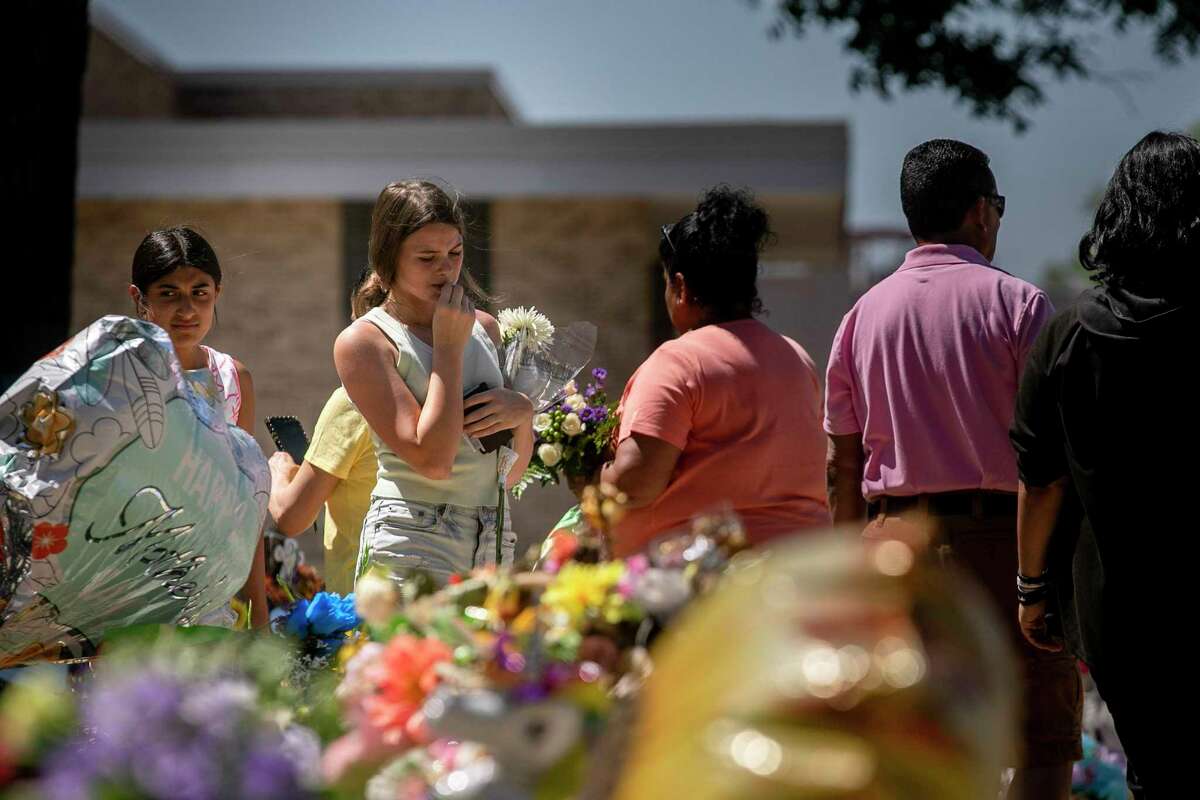 People pay their respects Saturday, June 11, 2022, at the memorial for the Robb Elementary School shooting victims at the town square in Uvalde.