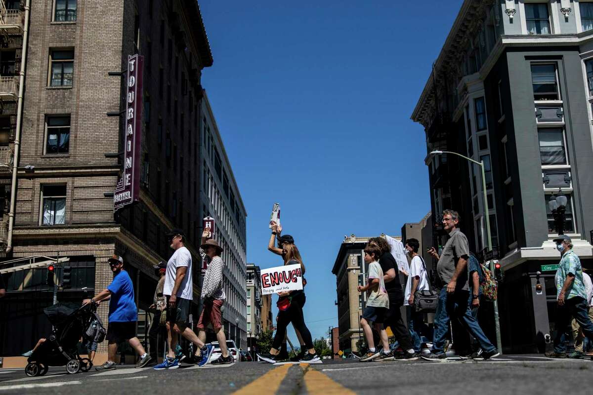 Demonstrators participate in a March for Our Lives protest against gun violence in Oakland on Saturday. The event, organized by Bay Area students, drew around 700 people who marched and wrote letters to politicians.