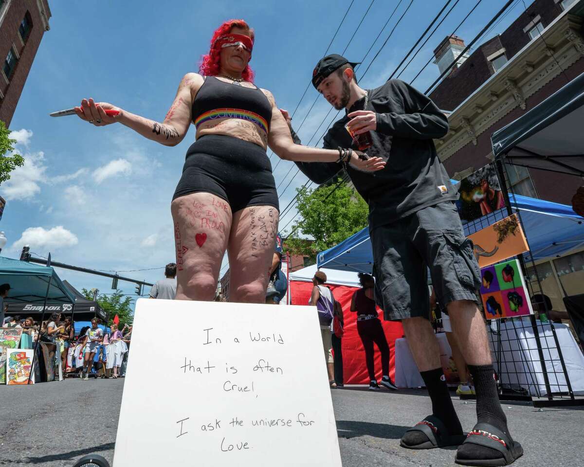 Matt Weinberg writes an inspirational message on Stephanie Levay during the Art on Lark street festival held on Lark Street on Saturday, June 11, 2022. (Jim Franco/Special to the Times Union)