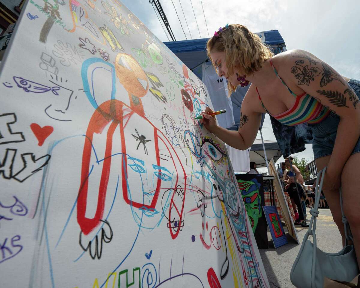 Hanna Bogart draws on a community art board during the Art on Lark street festival held on Lark Street on Saturday, June 11, 2022. (Jim Franco/Special to the Times Union)