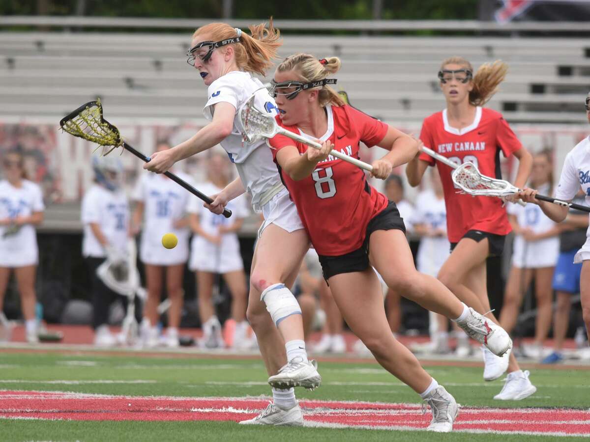 Darien’s Kate Demark (23) and New Canaan’s Devon Russell (8) battle for the ball during the CIAC Class L girls lacrosse final at Sacred Heart University on Saturday, June 11, 2022.