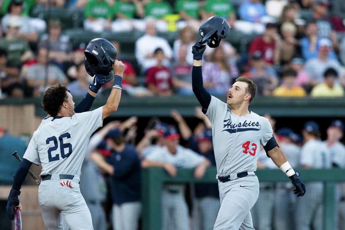 Connecticut's Matt Donlan (43) celebrates with Connecticut center fielder T.C. Simmons (26) after hitting a three-run home run against Stanford during the second inning of an NCAA college baseball tournament super regional game Saturday, June 11, 2022, in Stanford, Calif. (AP Photo/John Hefti)
