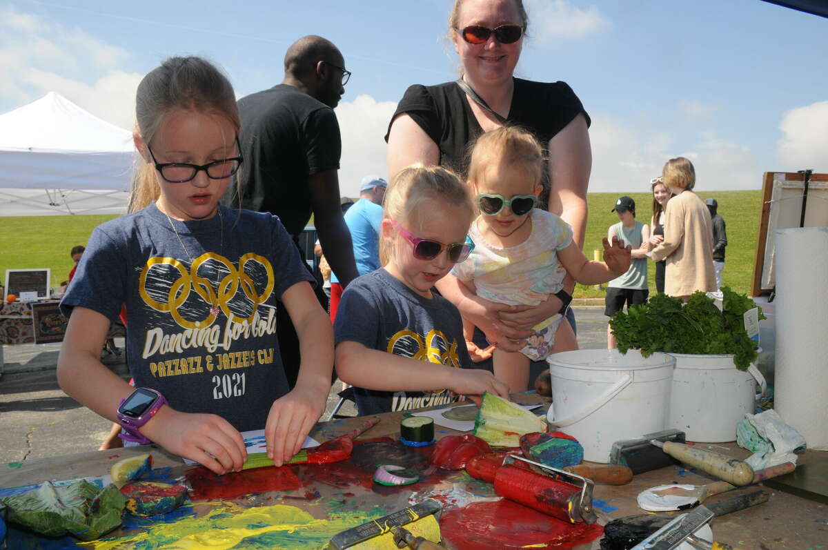 Seven-year-old Reagan, six-year-old Piper, and three-year-old Emma Lambie of Bethalto paint masterpieces during Art Play Day on Saturday at the Alton Farmers and Artisans Market.