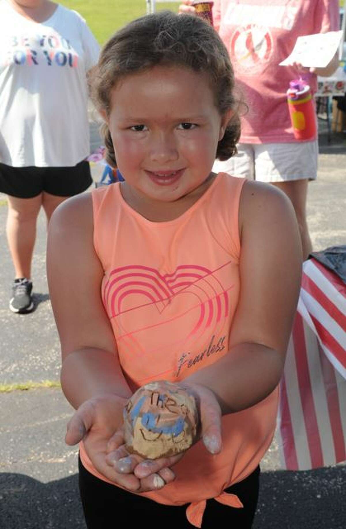 Eight-year-old Ella Reno of Granite City proudly displays a ceramic bell she made on Saturday during Art Play Day during the Alton Farmers and Artisans Market.