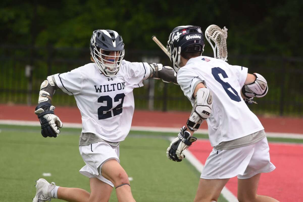 Wilton's Michael Wall (22) and Thomas McKiernan (6) celebrate a goal during Wilton's 22-6 win over Notre Dame-West Haven in the CIAC Class M championship game at Sacred Heart University Sunday.