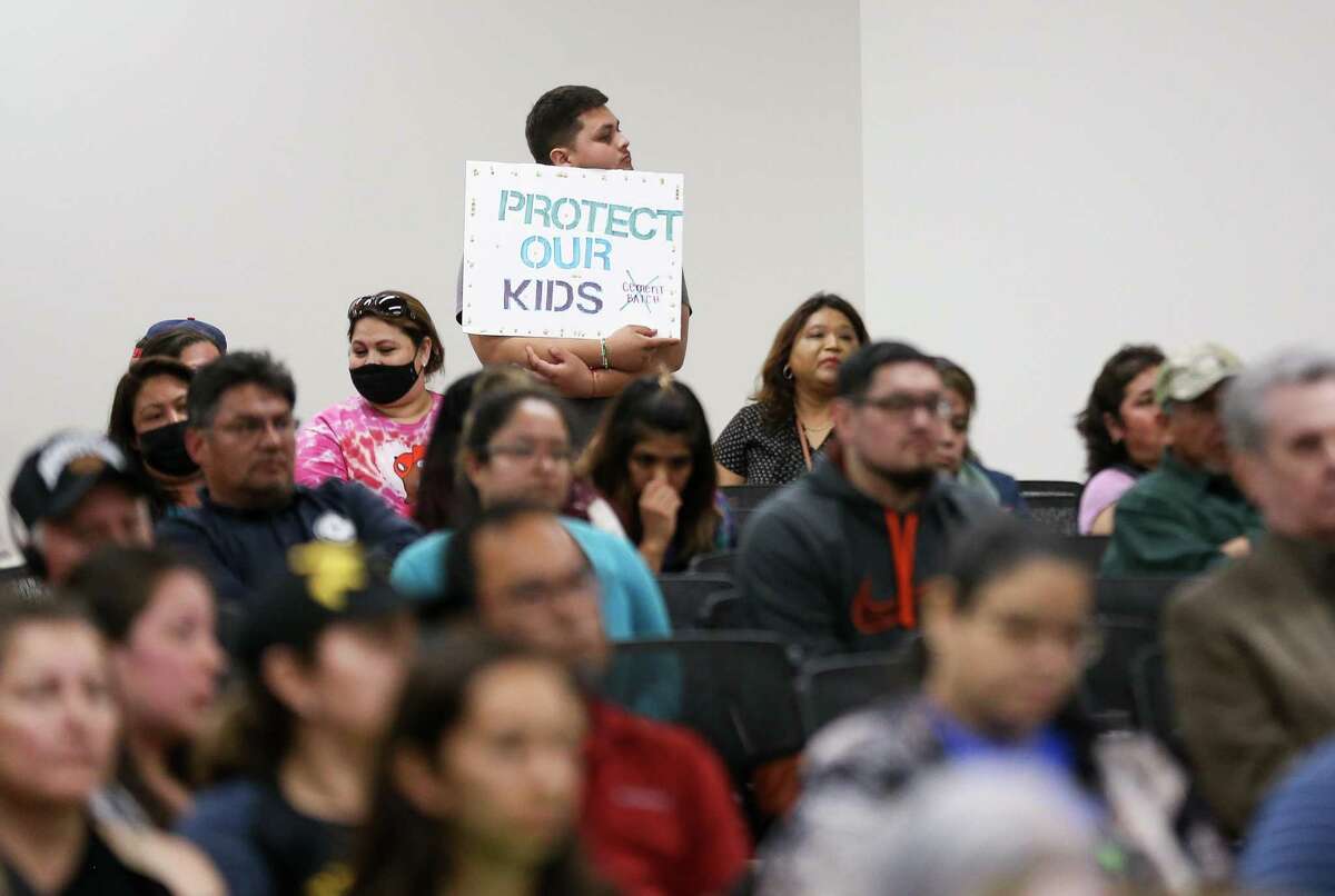 Aldine residents hold up signs in opposition to a proposed concrete batch plant during a public meeting by TCEQ at the East Aldine Management District building on Thursday, April 7, 2022, in Houston.
