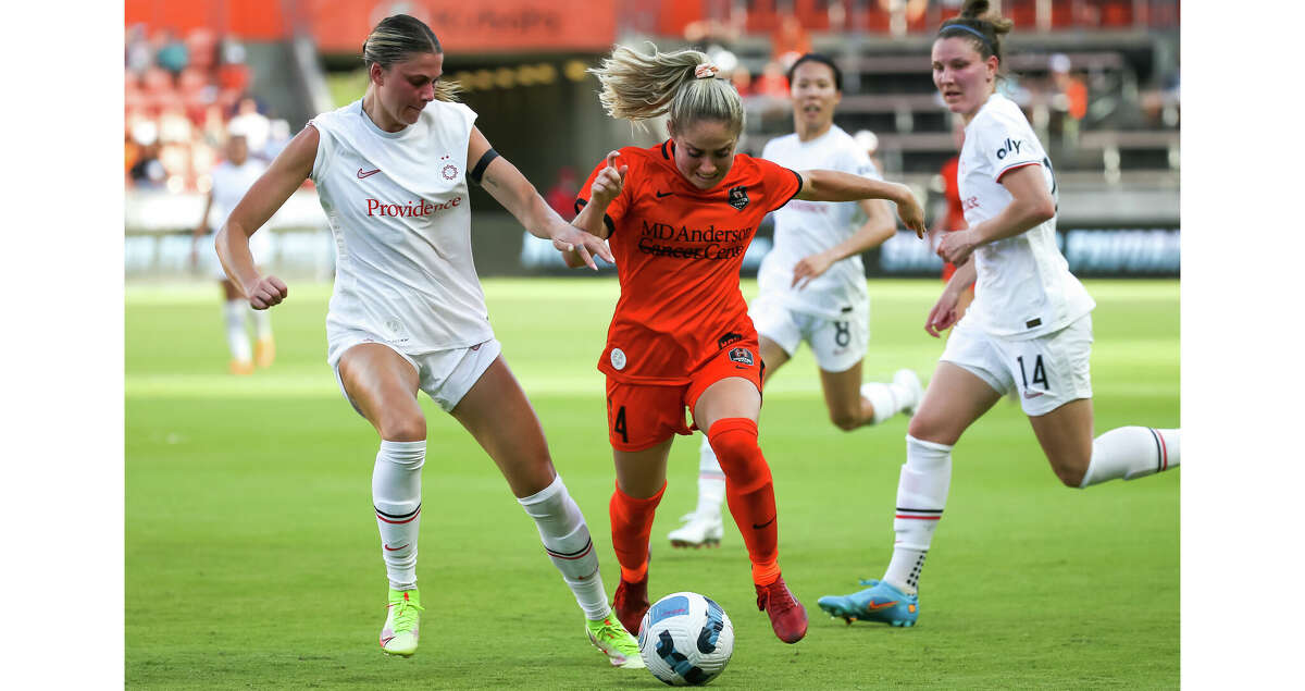 HOUSTON, TX JUNE 12: Houston Dash midfielder Bri Visalli (14) evades a challenge by Portland Thorns FC defender Kelli Hubly (20) in the first half during the NWSL soccer match between the Portland Thorns and Houston Dash at PNC Stadium in Houston, Texas.