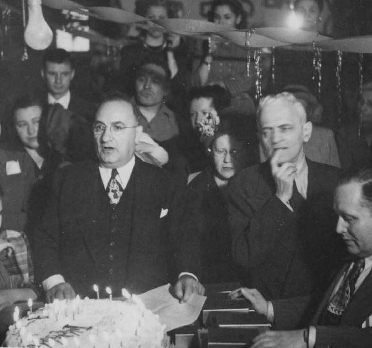 Leon Kahan, left, celebrates a major anniversary of Interstate Lumber in 1947.