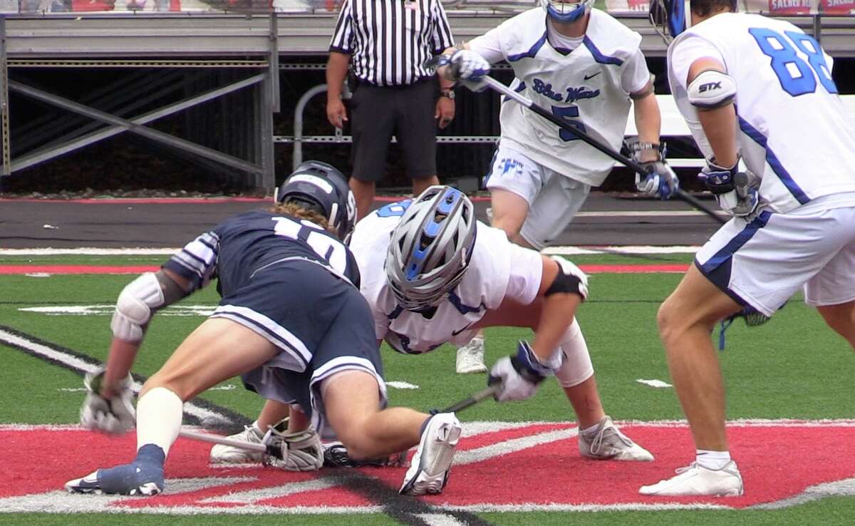Staples' Henry Dodge (right) battles Darien's Tighe Cummiskey during a faceoff in the 2022 Class L boys lacrosse championship at Sacred Heart University, Sunday, June 12, 2022. Dodge won 15 of 18 faceoffs as Staples won its first state title 12-3.
