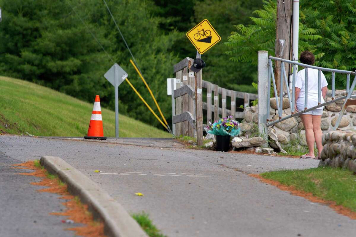 A woman looks over the area where New York State Police say that a speeding motorcyclist careened off Route 9 and crashed into a group of pedestrians near Lake George Expedition Park, killing a 38-year-old and an 8-year-old, seen here on Monday, June 13, 2022, in Lake George, N.Y. (Paul Buckowski/Times Union)