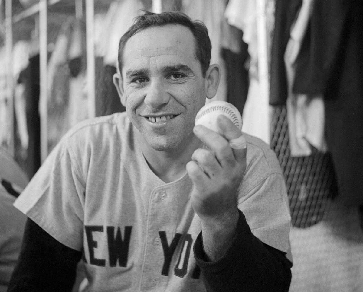(Original Caption) Yankee Yogi Berra set a new home-run record for catchers when he hit the 237th homer of his career during the 5th inning of the New York-Detroit game on September 14th. In this photograph, Berra holds the ball which he hit to make the new record.