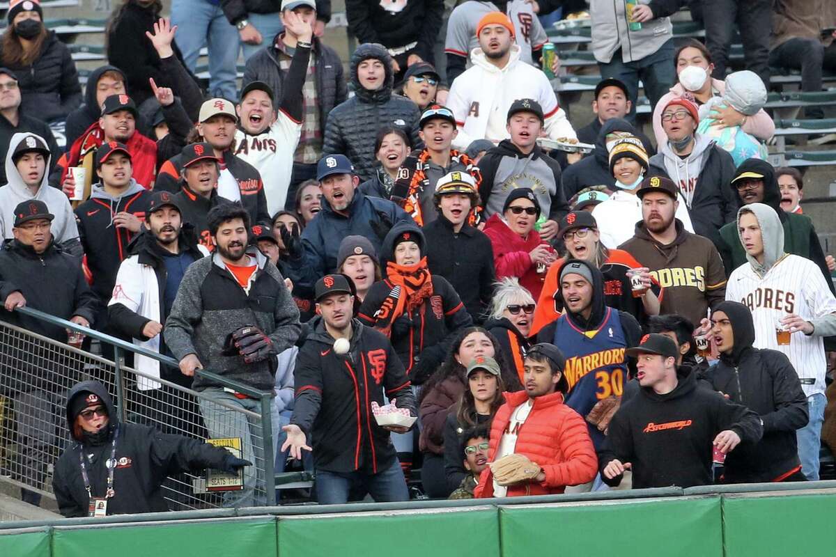 Fans in left field bleachers watch San Francisco Giants’ Brandon Belt’s 2-run home run in 1st inning against San Diego Padres during MLB game at Oracle Park in San Francisco, Calif, on Tuesday, April 12, 2022.