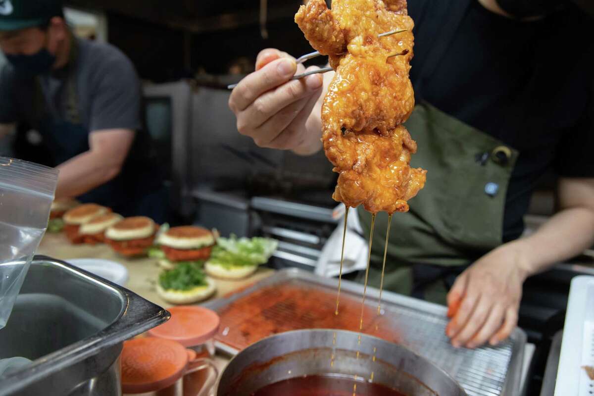 Kelvin Choy prepares the Hot Sichuan Chicken Sandwich at an Ok's Deli pop-up on Friday, May 14, 2021 in Oakland.