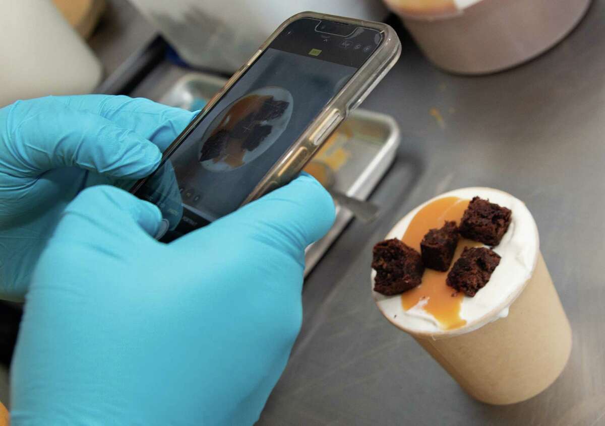 Underground Creamery owner Josh De Leon, 31, takes a photograph of a pint of Miso Banana Brownie Caramel ice cream for the week’s menu Thursday, June 9, 2022, in Houston. De Leon started making ice cream in 2018. Today, he's making 400 pints for a customer base of 4,000 from the kitchen he shares with Pudgy’s Fine Cookies.