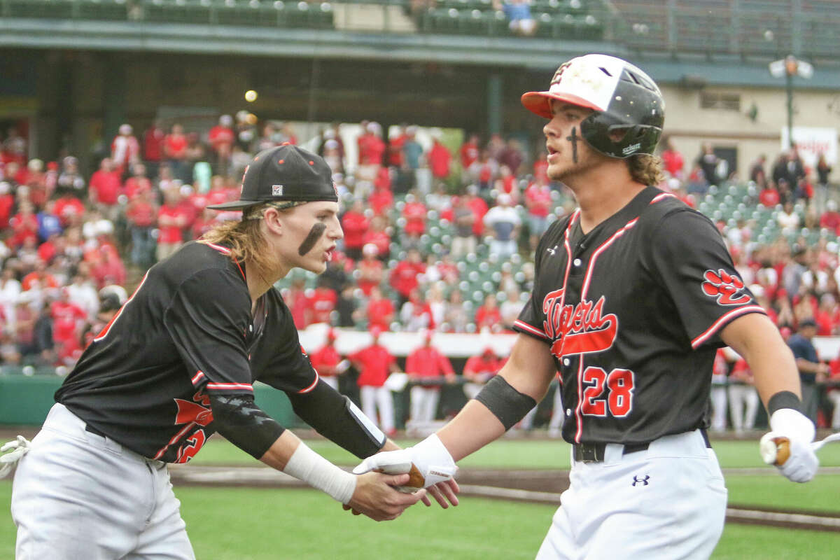 Grant Huebner (left) greets Spencer Stearns (right) into the dugout after Stearns hit a leadoff double in the seventh inning of the Class 4A state championship game. 