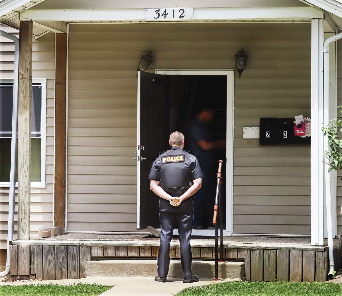 Alton Deputy Police Chief Jarrett Ford stands watch last Thursday over the entrance to the Bolivar Street apartment building where Liese A. Dodd, 22, was found beheaded and eight months pregnant. Police have arrested Deundrea S. Holloway, 22, of Litchfield, and charged him with two counts of first degree murder and two counts of intentional homicide of an unborn child. Dodd had an expected delivery date of mid-July. Holloway is in custody at the Alton Police Department.