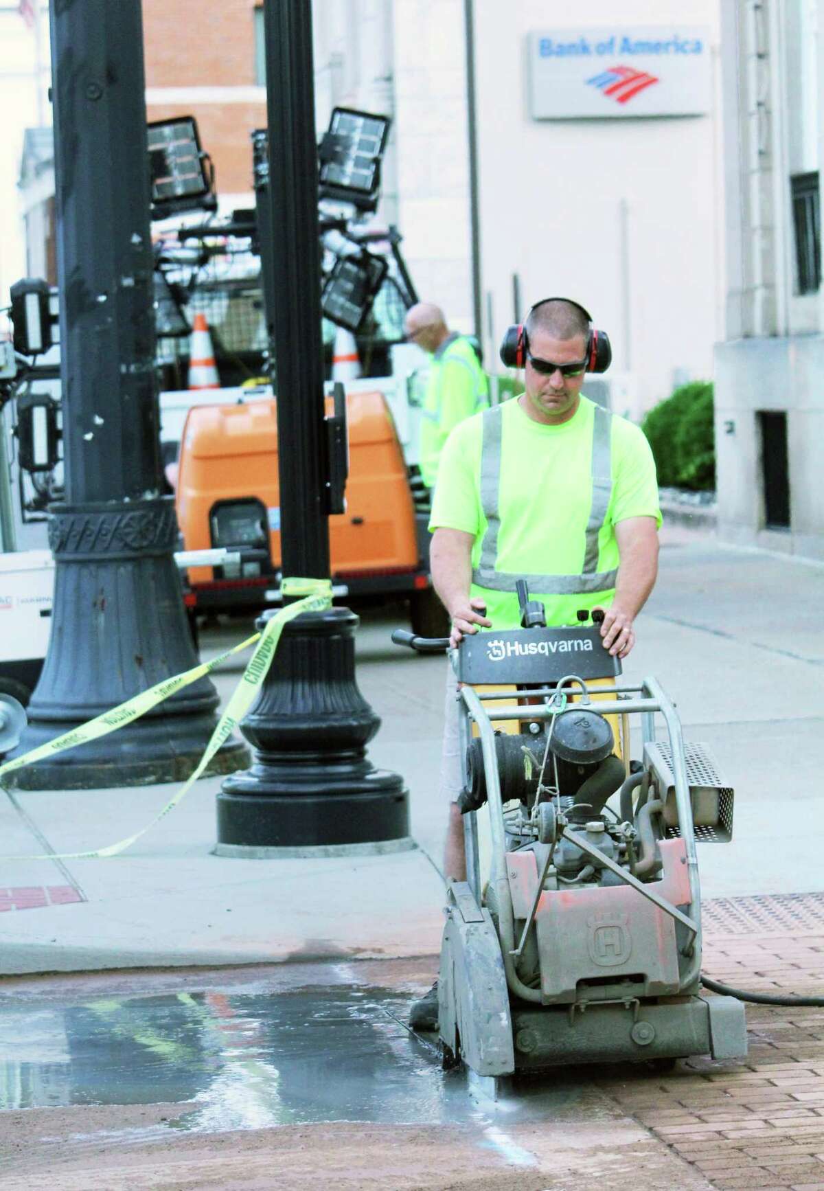 Crews repair the roadway on Main Street at the corner of Court Street Friday night after a major water main break at caused water to be reduced to a trickle at about six businesses in a block of Main Street.