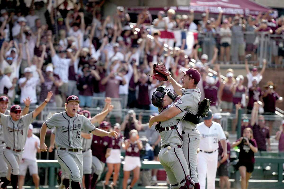 Pitcher Jacob Palisch, right, and catcher Troy Claunch embrace as their Texas A&M teammates storm the field in celebration of clinching a berth in the College World Series by completing a super regional sweep of Louisville on Saturday.