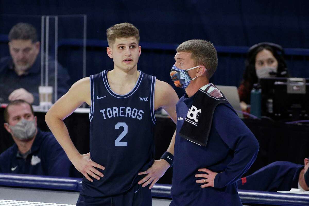 San Diego head coach Sam Scholl, right, speaks with guard Joey Calcaterra in 2021. Calcaterra will join UConn as a grad transfer.