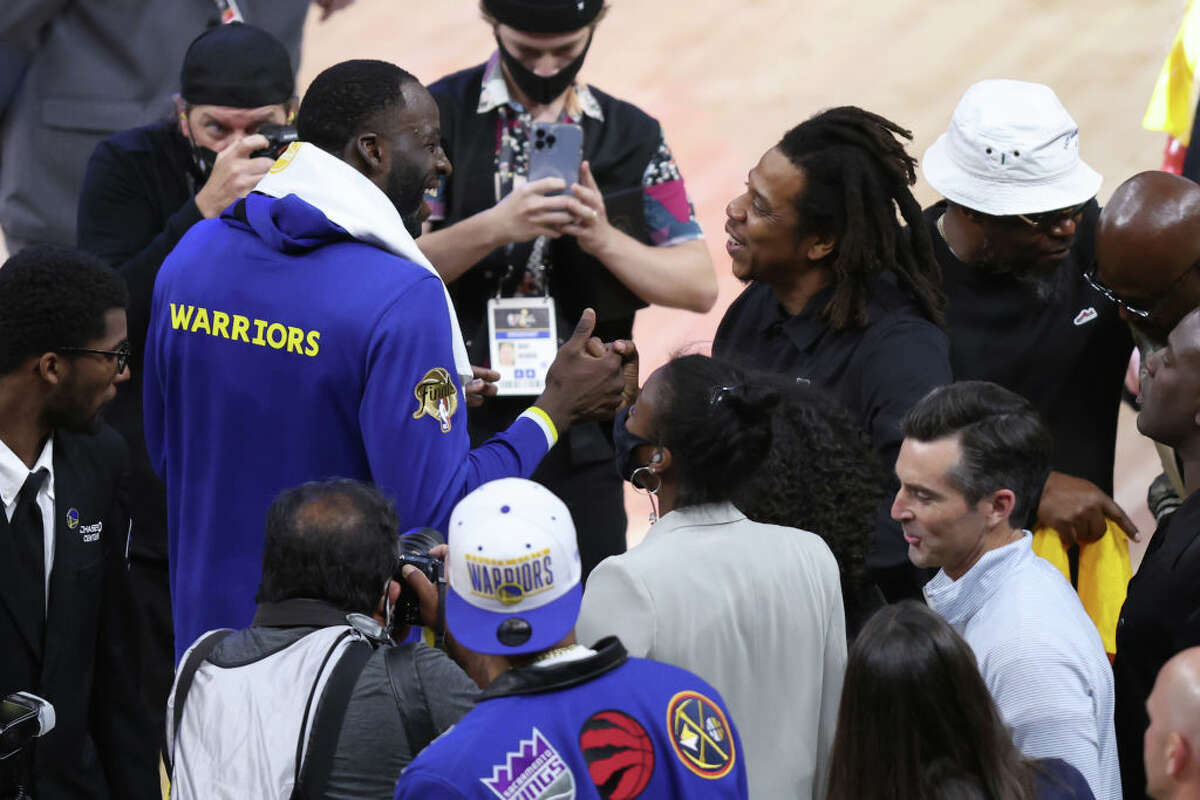 Draymond Green of the Golden State Warriors talks with rapper Jay-Z after the 104-94 win against the Boston Celtics in Game Five of the 2022 NBA Finals at Chase Center on June 13, 2022