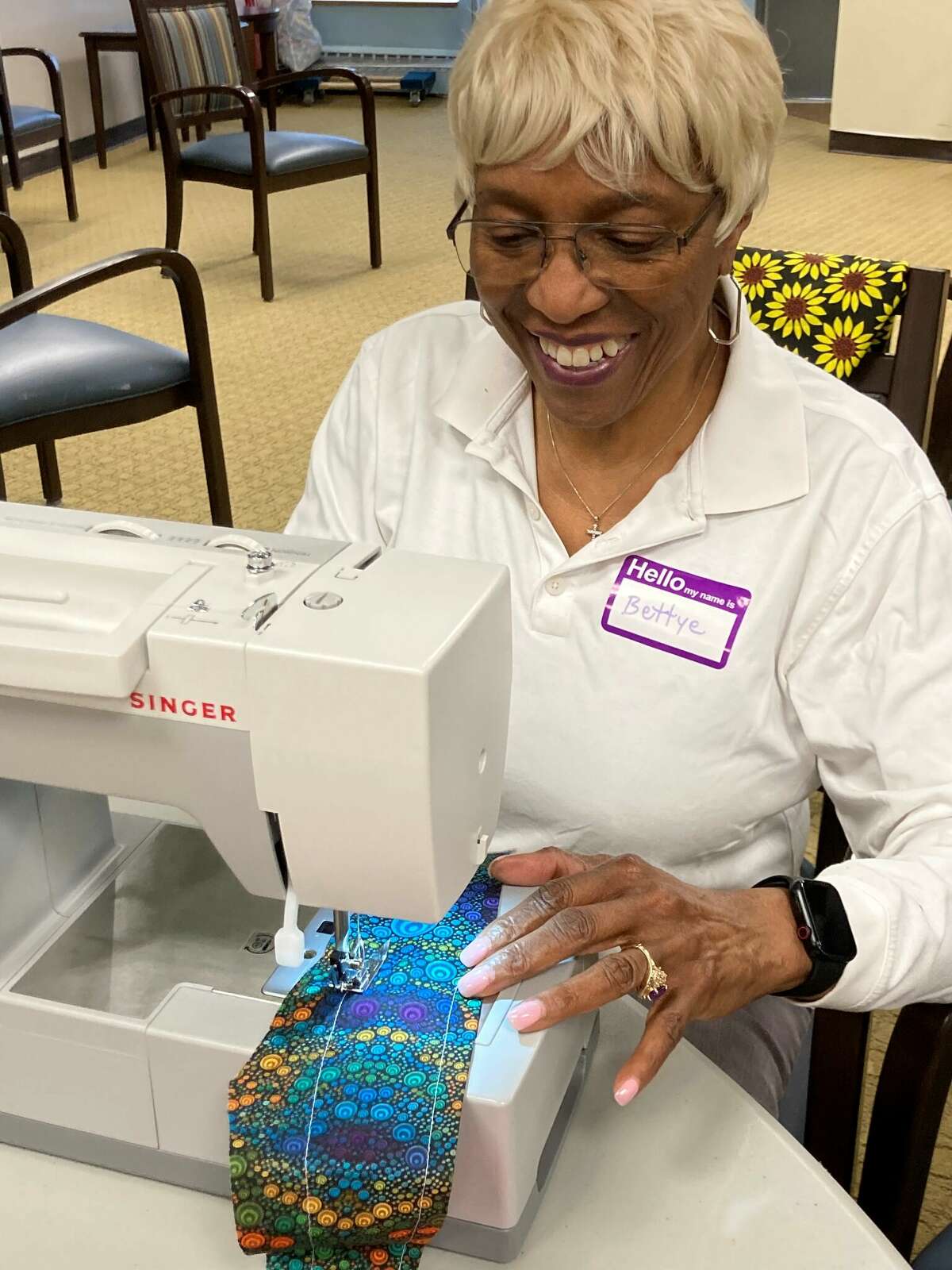 Bettye, a resident at The Towers, sews some fabric together to create a piece of clothing as part of one of the many programs offered through the Proactive Partner Model.