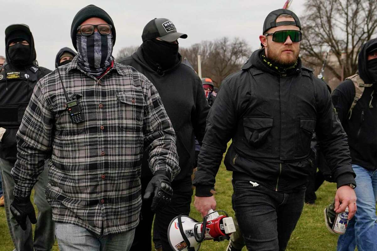 FILE - Proud Boys members Joseph Biggs, left, and Ethan Nordean, right with megaphone, walk toward the U.S. Capitol in Washington, Jan. 6, 2021. A federal judge on Tuesday, Dec. 28 refused to dismiss an indictment charging four alleged leaders of the far-right Proud Boys, Ethan Nordean, Joseph Biggs, Zachary Rehl and Charles Donohoe, with conspiring to attack the U.S. Capitol to stop Congress from certifying President Joe Biden's electoral victory.