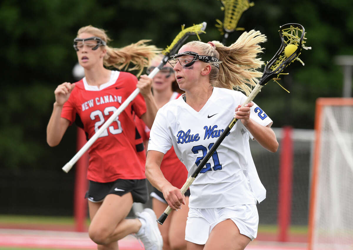 Darien's Kaci Benoit (21) breaks away with the ball during the CIAC Class L girls lacrosse final against New Canaan at Sacred Heart University on Saturday, June 11, 2022.