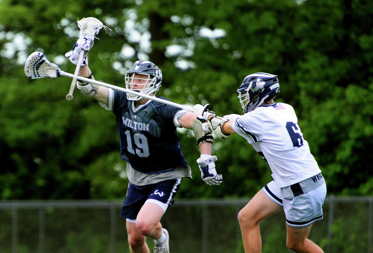 Staples' Andrew Gebicki, right, tries to disrupt a drive by Wilton's Grant Masterson during FCIAC boys lacrosse semifinal action at Brien McMahon High School Norwalk, Conn., on Tuesday May 24, 2022. Wilton beat Staples 7-6.