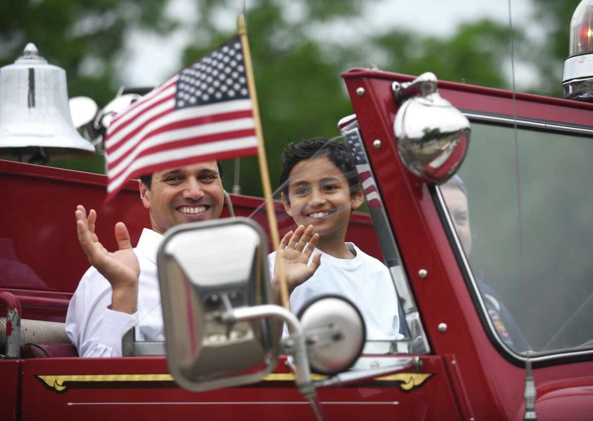 Third-grader Julian McRandal rides to school with his father in the front seat of a fire truck at Glenville School in the Glenville section of Greenwich, Conn. Tuesday, June 14, 2022. McRandal, who has brain cancer, was surprised Tuesday morning to be driven to school in a fire truck with a police motorcycle motorcade. The entire school was waiting outside to greet him, give him gifts, and honor him during a school assembly.