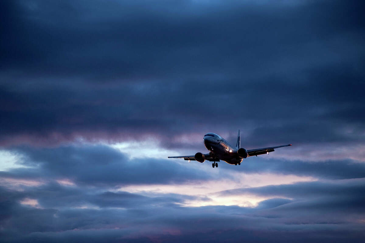 An Alaska Airlines jet in flight at sunset.
