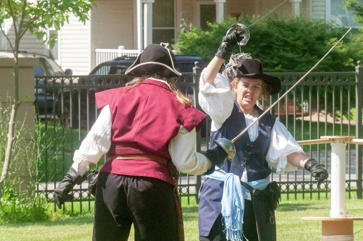 Maria Romine (left) and Charlie Woodruff of Swords and Roses perform Tuesday at Jacksonville Public Library. Romine and Woodruff were doing pirate-themed stunts to entertain children and adults. To see more photos, visit: myjournalcourier.com