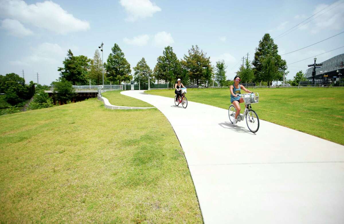 People bike along the newly completed construction and a new park and 0.4-mile hike and bike trail along Buffalo Bayou from Fannin Street to Austin Street at Allen’s Landing, downtown, on Tuesday, June 14, 2022 in Houston. Houston Parks Board and Buffalo Bayou Partnership, in cooperation with the Downtown Redevelopment Authority and the City of Houston Parks and Recreation Department opened the trail to the public, Monday. Weaving under and through buildings adjacent to the waterfront just east of Allen’s Landing, this new addition represents a key connection between downtown and points east, furthering Buffalo Bayou Partnership’s goal to create connectivity all the way from Buffalo Bayou Park to the Port of Houston Turning Basin. It also aligns with Houston Parks Board’s goal to create an interconnected system of parks and trails across Houston through Bayou Greenways.