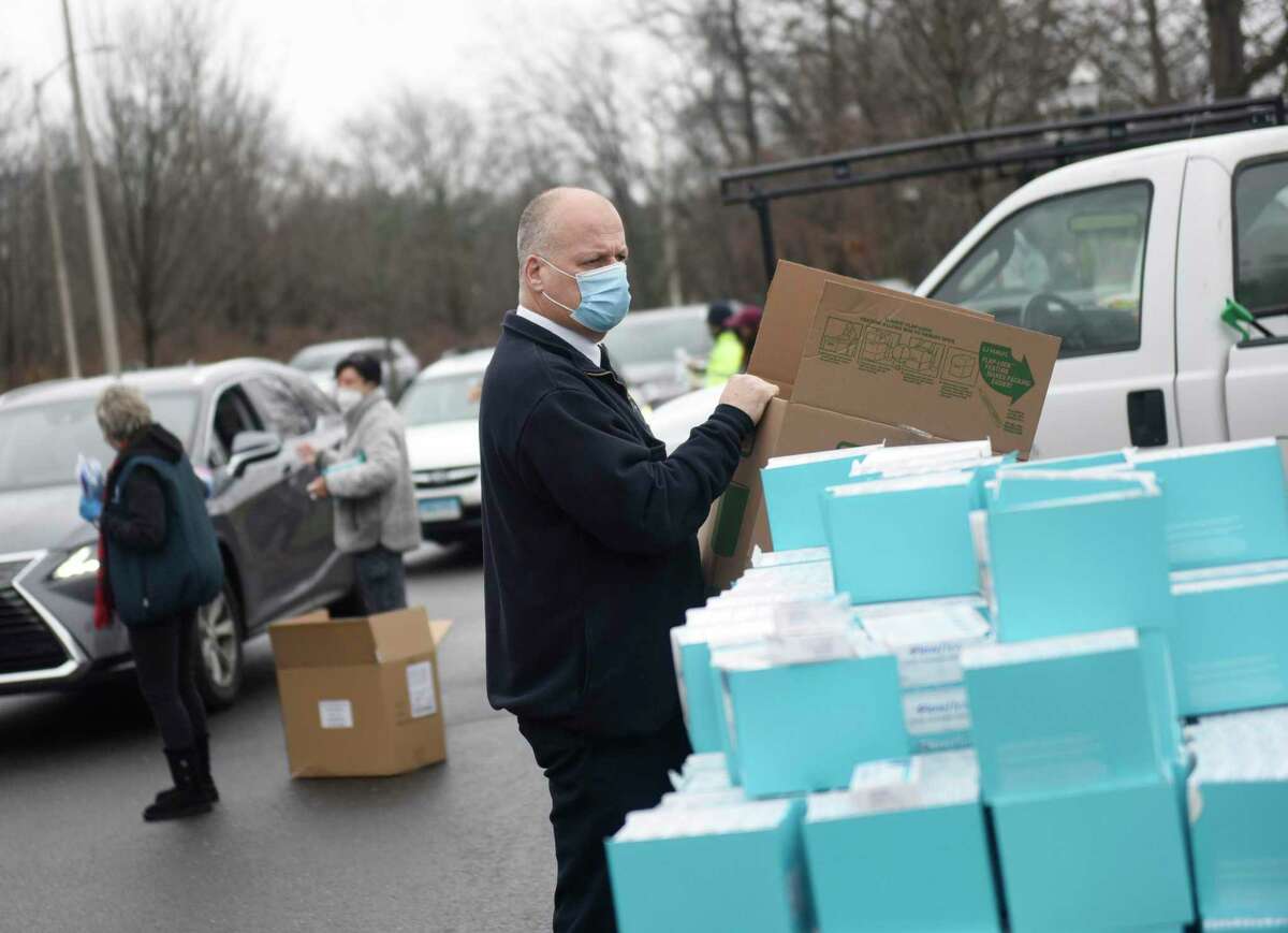 Stamford Director of Public Safety, Health and Welfare Ted Jankowski helps distribute COVID test kits at Scalzi Park in Stamford, Conn. Sunday, Jan. 2, 2022.