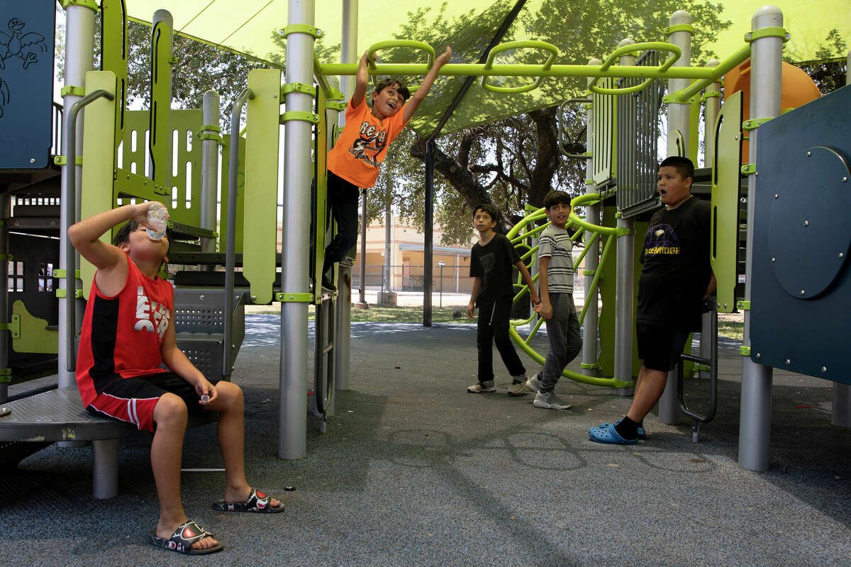 From left to right, Izaiah Valdez, Has Habibi, Jacob Torres, Abdullah Habibi, and Jaiden Cruz pass time on the playground outside the San Juan Community Center waiting for the it to open so they could play inside in the air-conditioning.