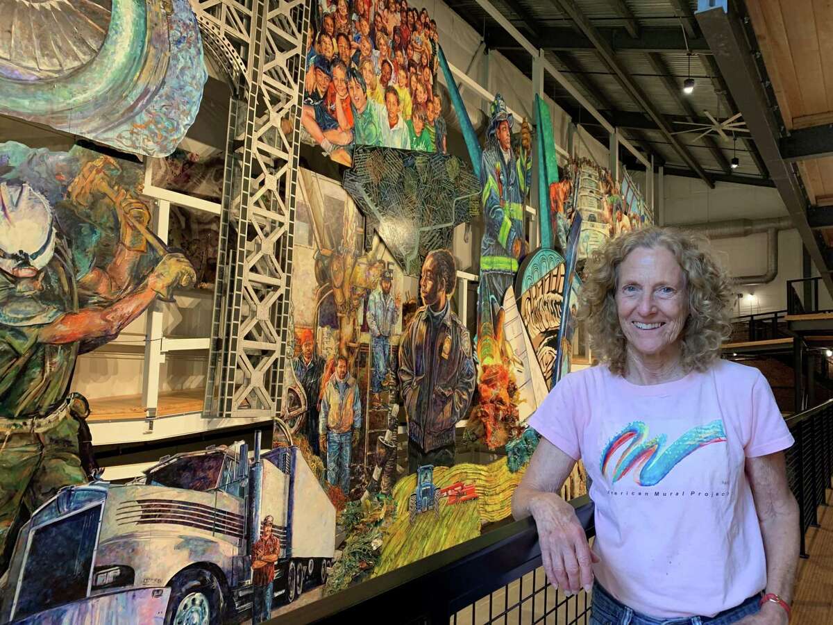 Ellen Griesedieck stands in front of the mural at the American Mural Project that has been over two decades in the making.