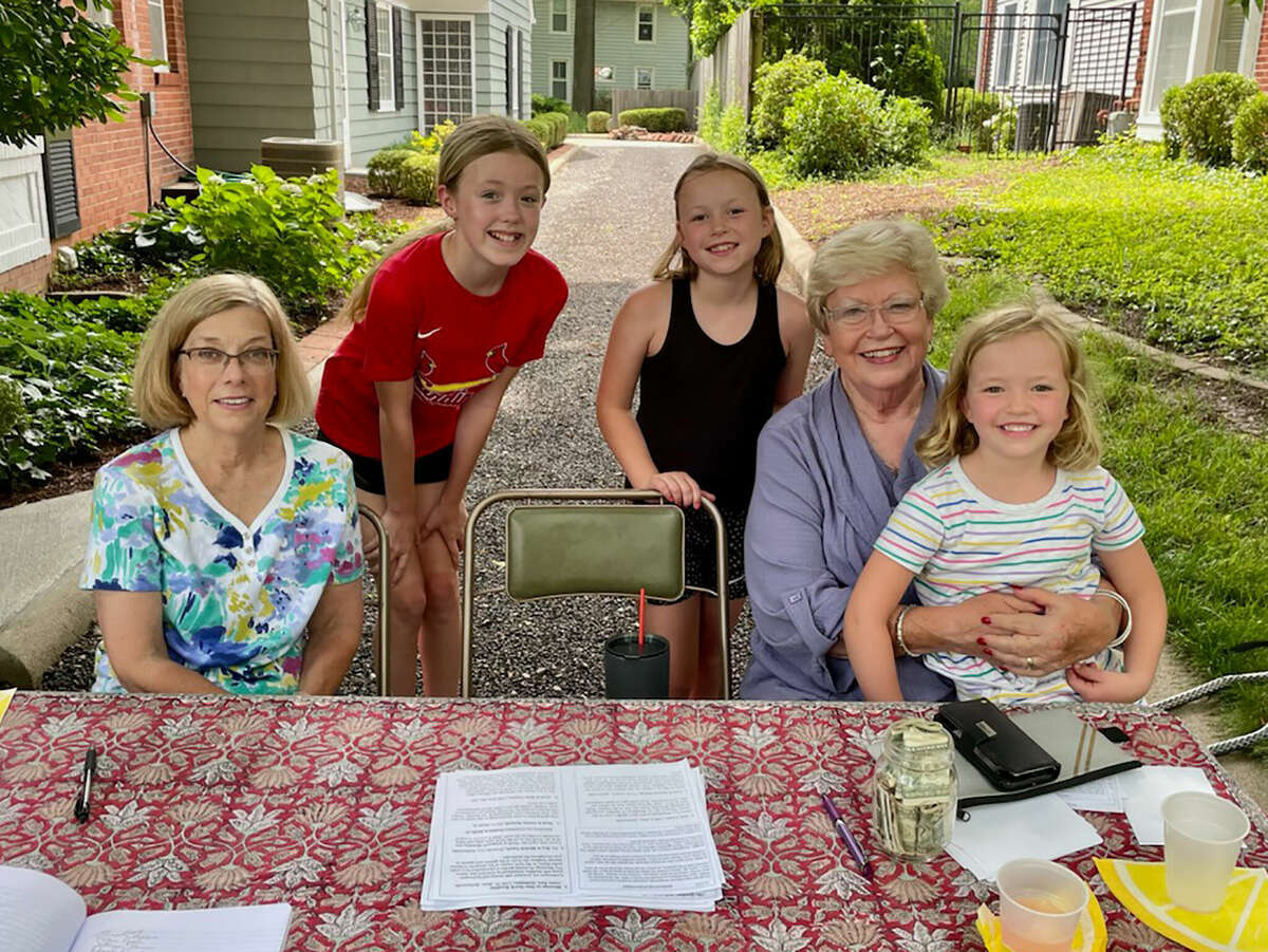 Morgan County Garden Club members Kelly Clancy (left) and Joyce Clancy (second from right) sit with sisters Collins Reed (from right), 5, and Cora Reed, 9, and their friend, Lucy Valentine, 10, during the club's Sunday afternoon garden walk. The girls, who live across the street from one of the garden walk's featured homes, set up a lemonade stand during the walk, then donated the proceeds to the club.