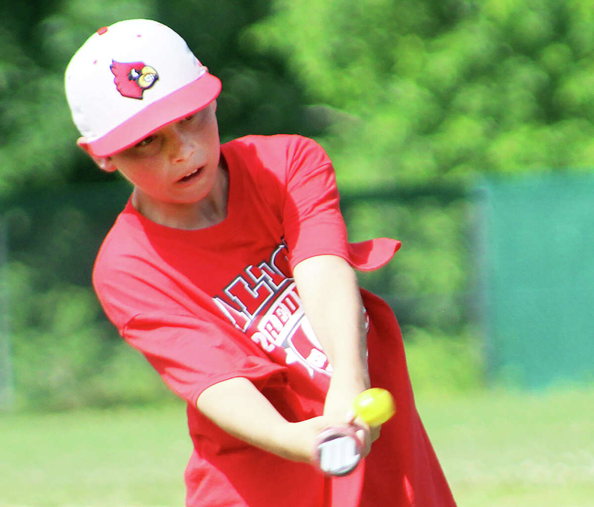 Keeping his head in and watching the ball, baseball camper Gavin Schrock makes connection with the batting practice ball on Wednesday during the Redbirds Baseball Camp at Alton High.